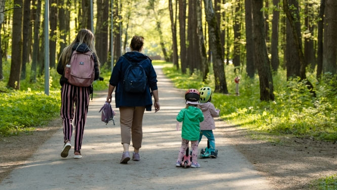Sievietes ar bērniem pastaigājas parkā